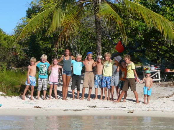 de kids van alle andere boten om ons heen verzameld op het strand van Green Island