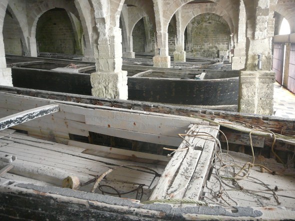 oude roeiboten voor de tonijnvangst in hun boothuis van de tonijnfabriek